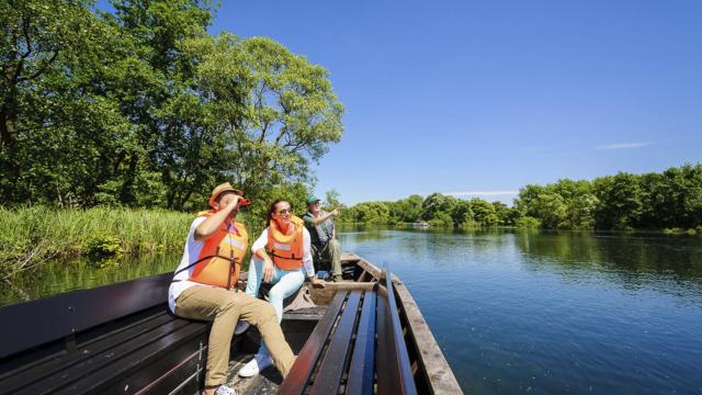 Eine Gruppe im Flachkahn beobachtet mit dem Fernglas das Leben im Insel-Moor von Saint-Quentin, Nordfrankreich. Copyright: CRTC Hauts-de-France - Vincent Colin