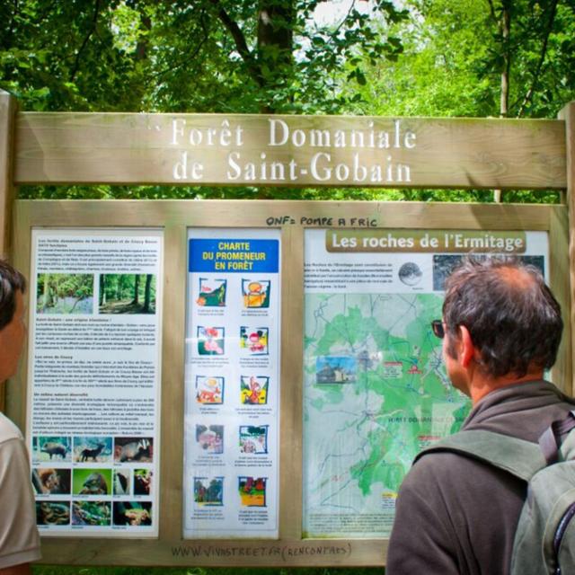 Wanderer vor einer Wegtafel im Wald Saint-Gobain, Copyright: Aisne Tourisme - Amin Toulors