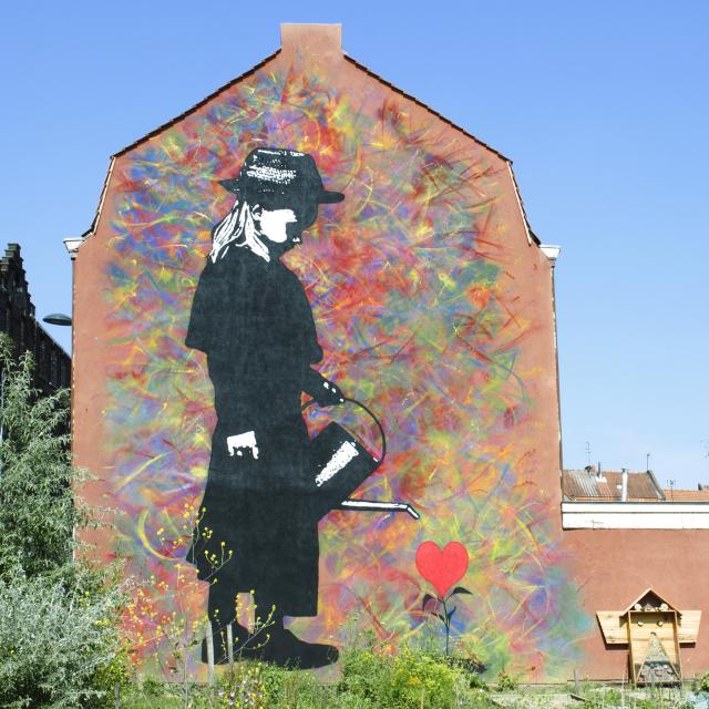 Street Art in Roubaix: Mann, der ein Herz als Blume gießt, Copyright: Roubaix Tourisme