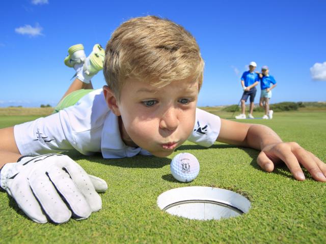 Junge versucht, Golfball ins Ziel zu pusten in Wimereux beim Kindergolfkurs in Nordfrankreich. Copyright: CRTC Hauts-de-France - AS Flament