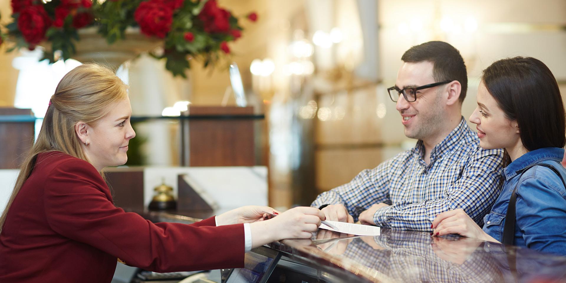 Voyageurs à l'accueil de l'hôtel © Pressfoto - Freepik
